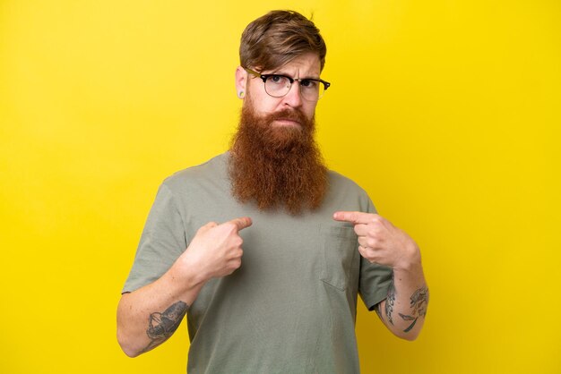 Foto roodharige man met baard geïsoleerd op gele achtergrond wijzend naar zichzelf