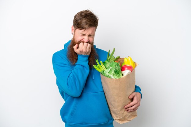 Roodharige man met baard met een boodschappentas geïsoleerd op een witte achtergrond met twijfels