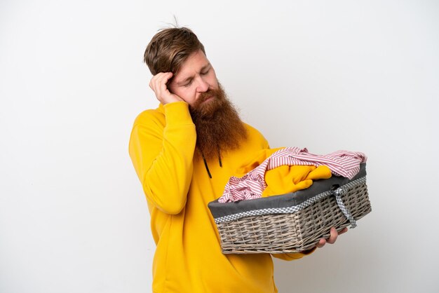 Roodharige man met baard met een wasmand geïsoleerd op een witte achtergrond met hoofdpijn