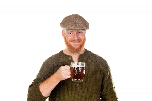 Roodharige man met lange baard een biertje drinken