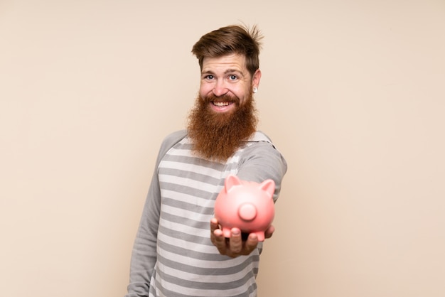 Roodharige man met lange baard met een grote spaarpot