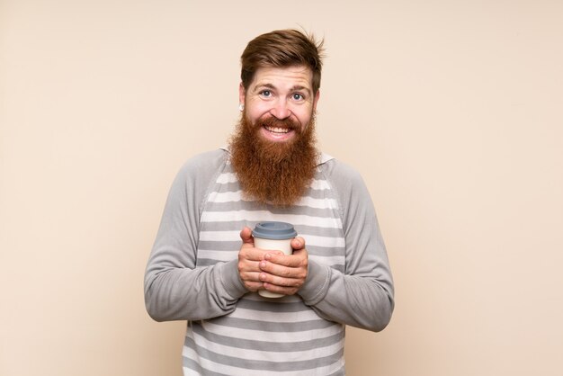 Roodharige man met lange baard over geïsoleerde muur koffie weg te nemen