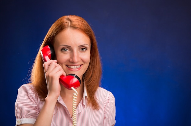 Roodharige meisje met rode telefoon