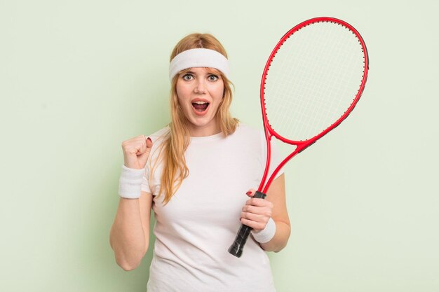 Roodharige mooie vrouw die agressief schreeuwt met een boos expressietennisconcept