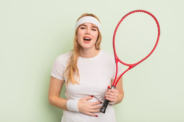 Roodharige mooie vrouw die hardop lacht om een of andere hilarische grap. tennisconcept