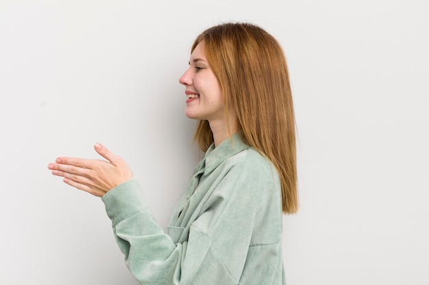 Roodharige mooie vrouw die lacht en je begroet en een hand schudt om een succesvol samenwerkingsconcept te sluiten