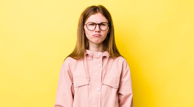 Roodharige mooie vrouw die verdrietig en zeurt met een ongelukkige blik die huilt met een negatieve en gefrustreerde houding