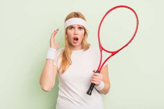 Roodharige mooie vrouw schreeuwen met handen omhoog in de lucht tennis concept