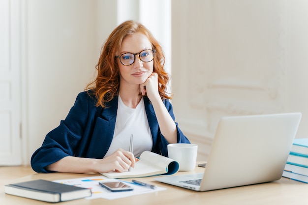 Roodharige vrouw analyseert gegevens en rapporteert