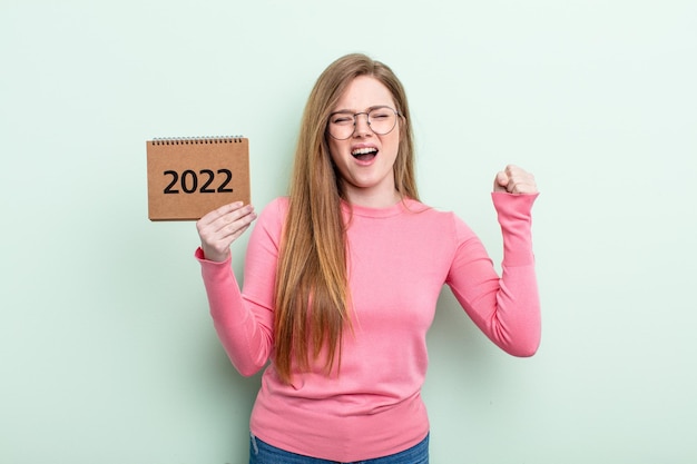 Roodharige vrouw die agressief schreeuwt met een boze uitdrukkingsagenda 2022 concept