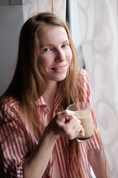 Roodharige vrouw koffie drinken in de ochtend