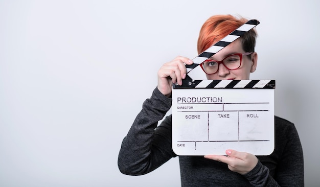 roodharige vrouw op witte achtergrond met film klepel bioscoop concept