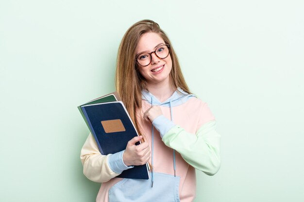 Roodharige vrouw voelt zich gelukkig en staat voor een uitdaging of feest. studentenconcept