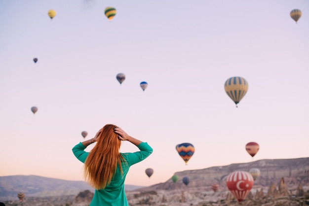 Roodharige vrouwelijke toerist die uitzicht bewondert in cappadocië