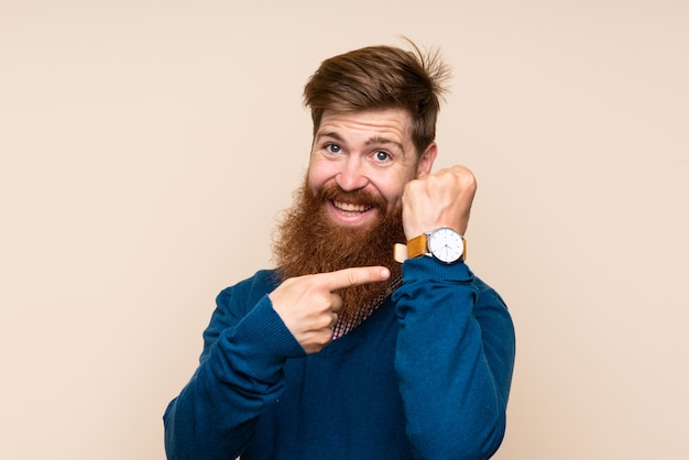 Roodharigeman met lange baard met het handhorloge