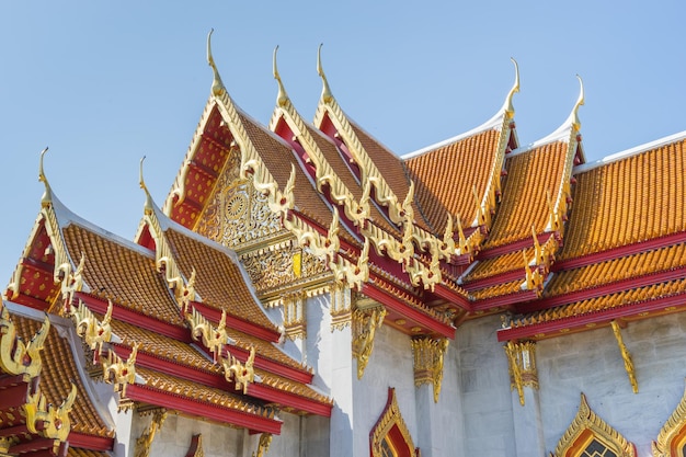 青い空の下でタイのバンコクの大理石の寺院の屋根のエレガントなタイの芸術