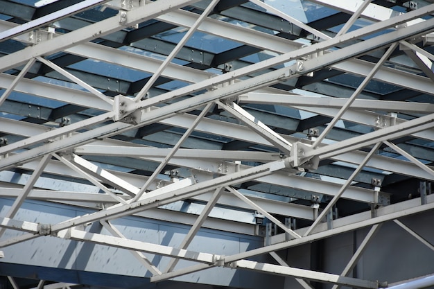 A roof made of large metal structures and a glass of a modern building