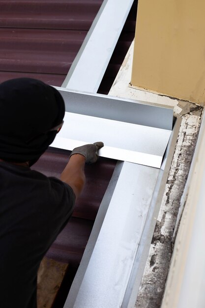 Roof repair, Worker with steel sheet. Stop a roof leak