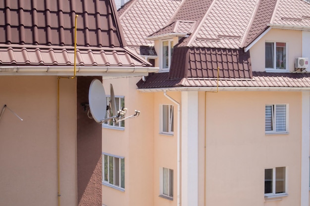 Roof on residential property with new brown corrugated metal\
roof tiles. modern metal roof. metal roofing.