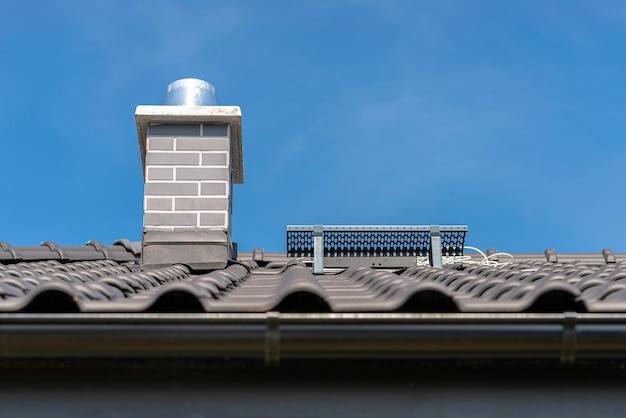 Foto il tetto di una casa unifamiliare coperto da una nuova piastrella ceramica in antracite contro il cielo blu