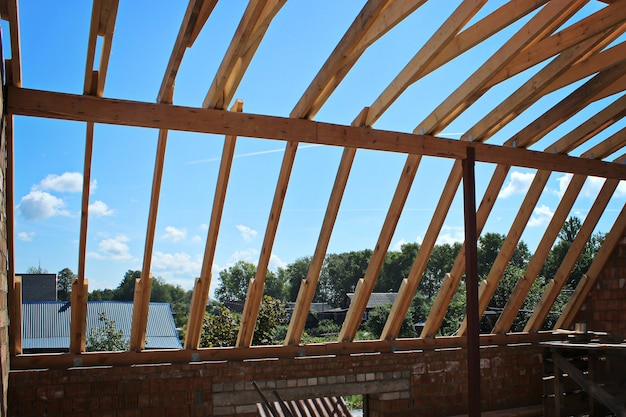Roof trusses not covered with ceramic tile on detached house under construction,visible roof elements, battens, counter battens, rafters. Industrial roof system with wooden timber, beams and shingles.