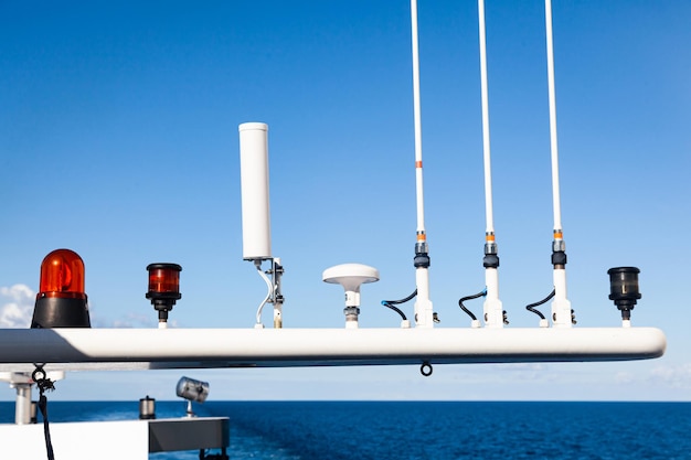 Roof of yacht with navigation radars and satellite dishes against the background of the sea and sky