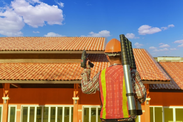 Foto l'operaio edile del roofer installa un nuovo tetto, strumenti per tetti, trapano elettrico utilizzato su nuovi tetti con lamiera metallica.