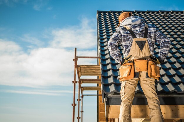 Photo roofer contractor worker on a scaffolding new house construction roofing job