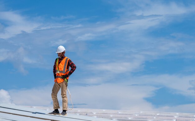 Roofer working in protective work wear gloves,construction worker wearing safety harness working at high level in the construction site install new roof,metal roof