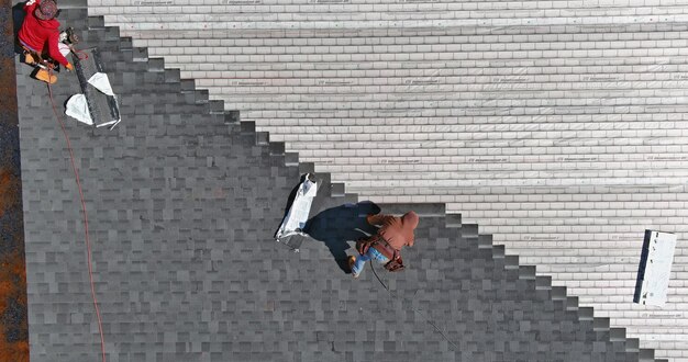 Roofing Construction With Roofer Hands Installing Asphalt Shingles On House The Hammer And Nails