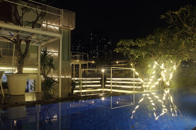 Foto piscina sul tetto di notte con caffè sullo sfondo