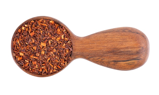 Rooibos red tea in wooden spoon, isolated on white background. Traditional herbal and organic tea. Top view.