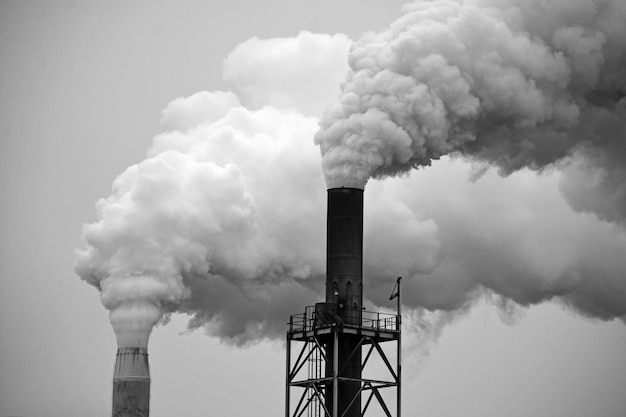 Rook uit de fabriek tegen een bewolkte hemel.