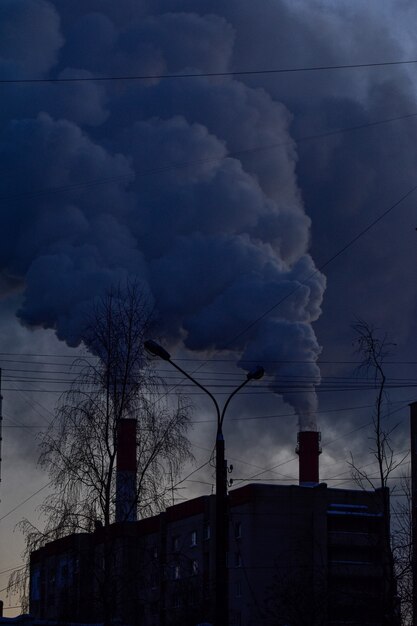 Rook uit industriële leidingen bij zonsondergang