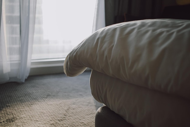 Room interior with bed closeup and white bed fabric cloth\
blanket and bed sheet