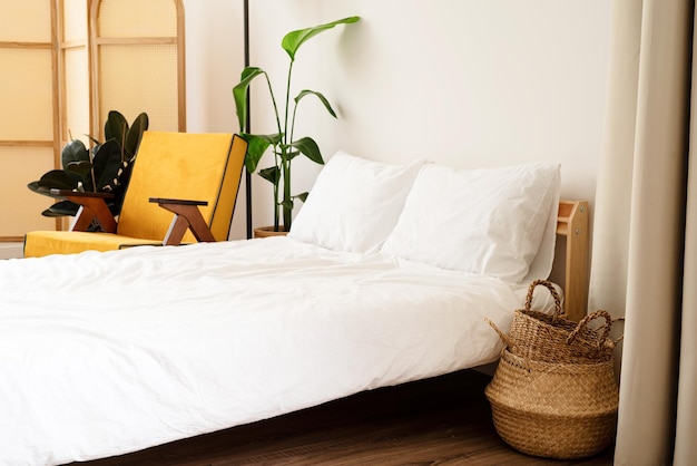 Room interior with comfortable yellow chair bed and plant near\
white wall