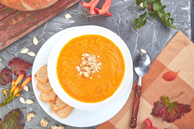 Room van pompoensoep op een grijze achtergrond. Dieet vegetarisch