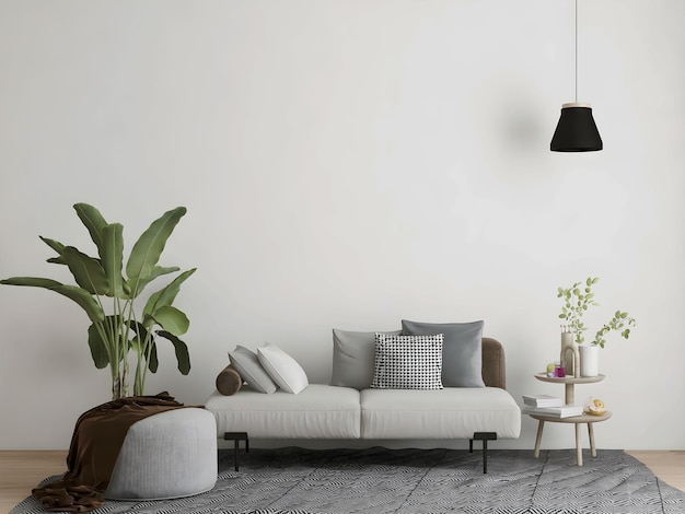 Room with grey sofa and pillows, stool and blanket, plant, carpet, hanging lamp, and empty wall.