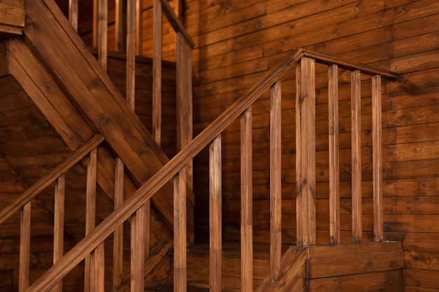 Room with wooden stairway leading to second floor of modern flat.