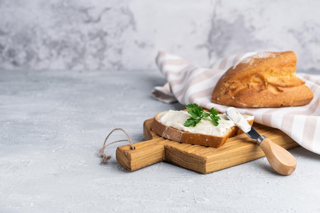 Foto roomkaas met kruiden en kruiden op vers knapperig roggebrood met kaasmes in de buurt