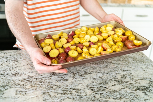 Foto roosteren van gehalveerde gemengde marmeren aardappelen in de moderne keuken