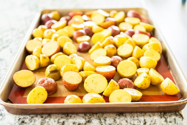 Roosteren van gehalveerde gemengde marmeren aardappelen in de moderne keuken