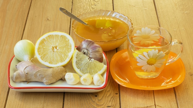 The root of ginger and honey on wooden table.