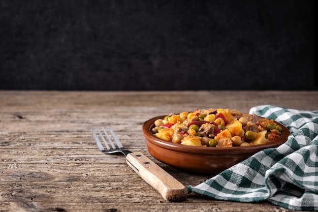 Ropa vieja food in bowl on rustic wooden table.