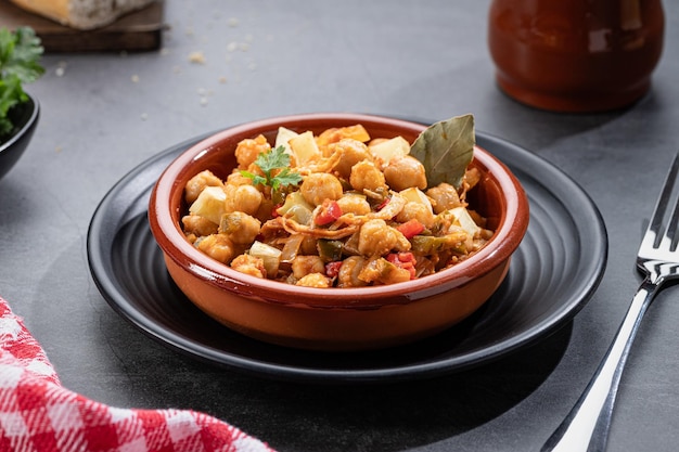 Foto ropa vieja piatto tipico delle canarie di stufato di ceci con pollo e patate in un vaso di terracotta