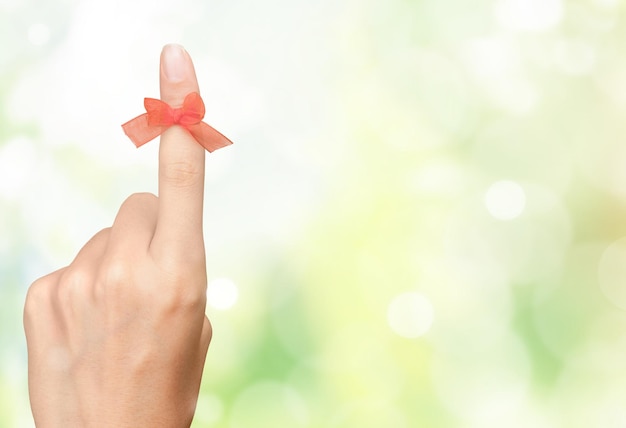 Rope bow on finger pointing on blurred background