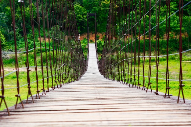 Rope bridge with wood planks across over the river 
