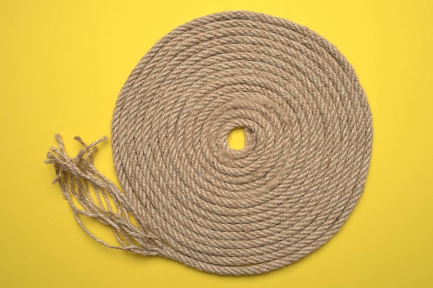 Rope folded in a spiral on yellow background