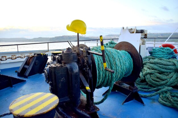 A rope is on a boat with a yellow hard hat on it.