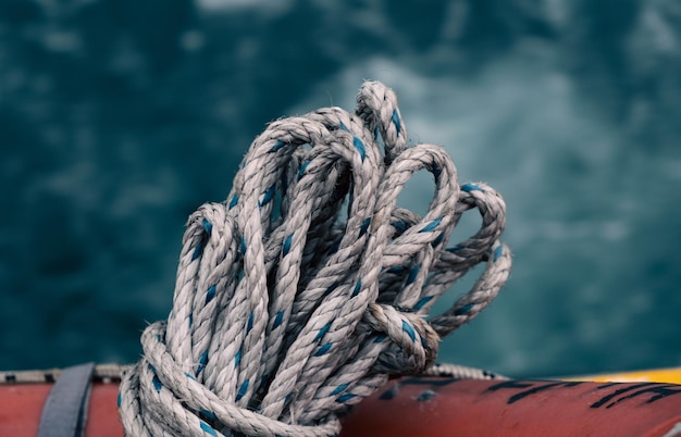 A rope is tied to a pole in front of the water.